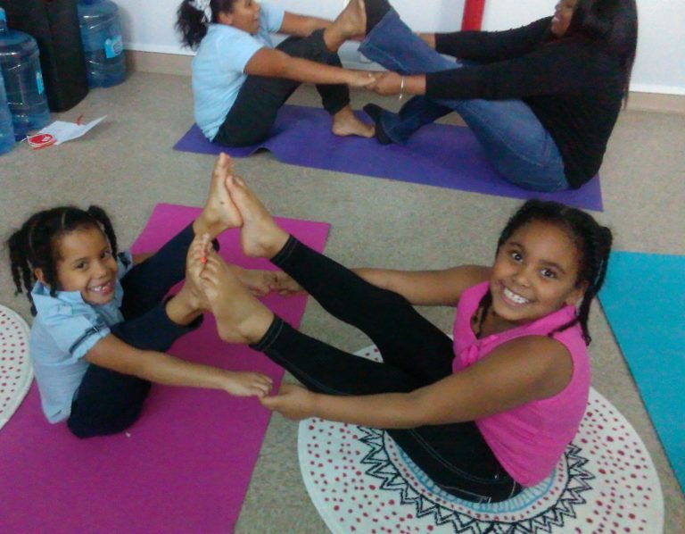 Student meditating Woman in a blue outfit meditating in a serene indoor setting.